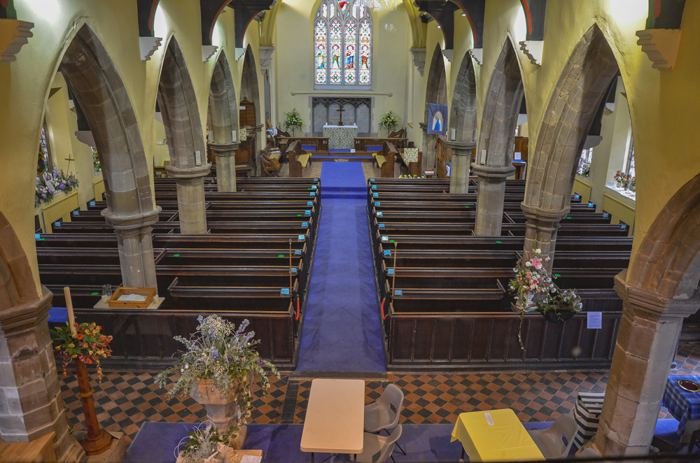 The nave of St Michael & All Angels, decorated with flowers and looking east towards the chancel